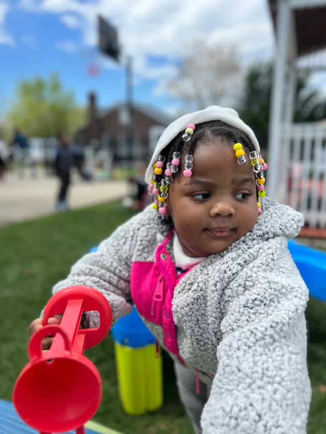 Toddler playing with sand toys on the playground