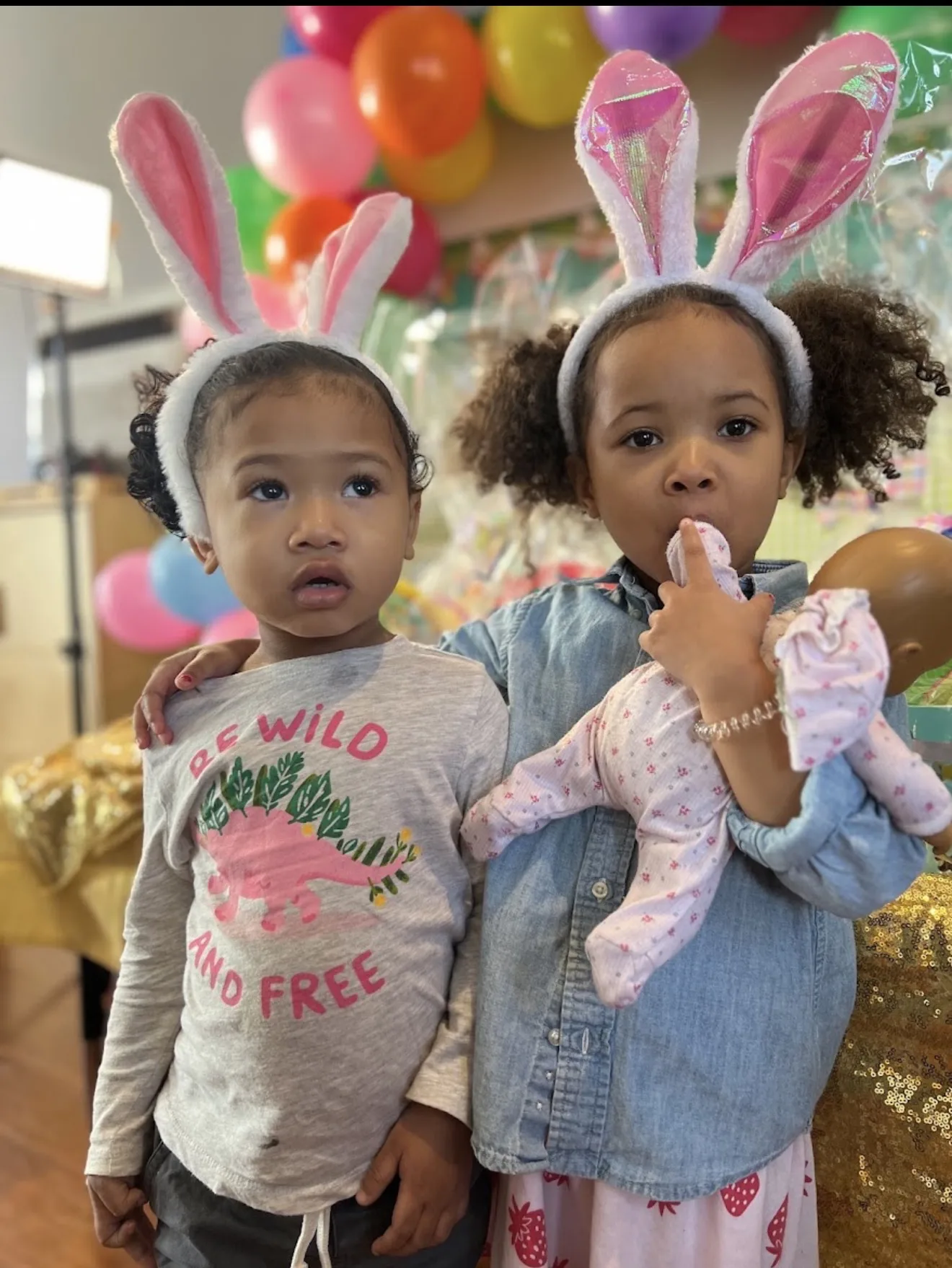 Two girls wearing bunny ears at a spring celebration