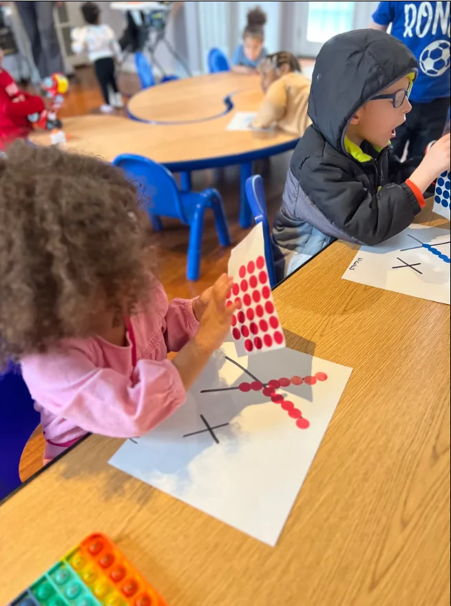Children practicing fine motor skills with a dot sticker craft