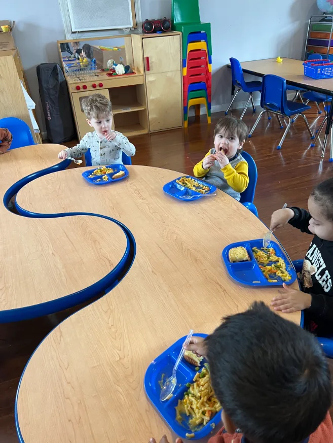 Children enjoying lunch together at the classroom table